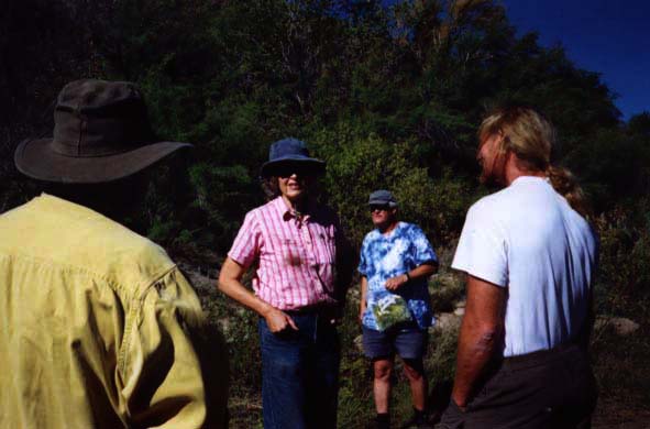 Trip participants milling on the bank of the river before disembarking